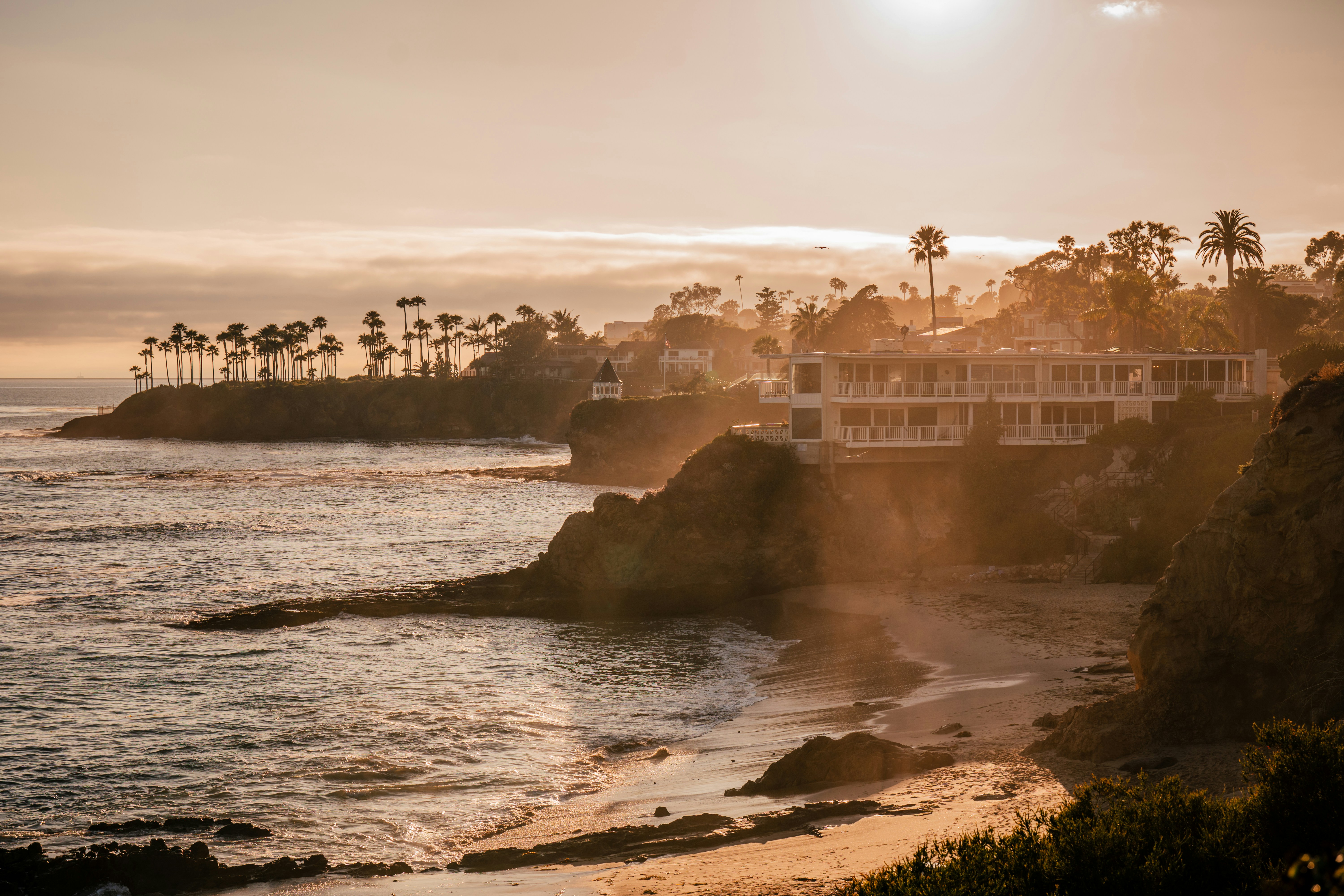 Coastal resort on a cliff overlooking the ocean at sunset.