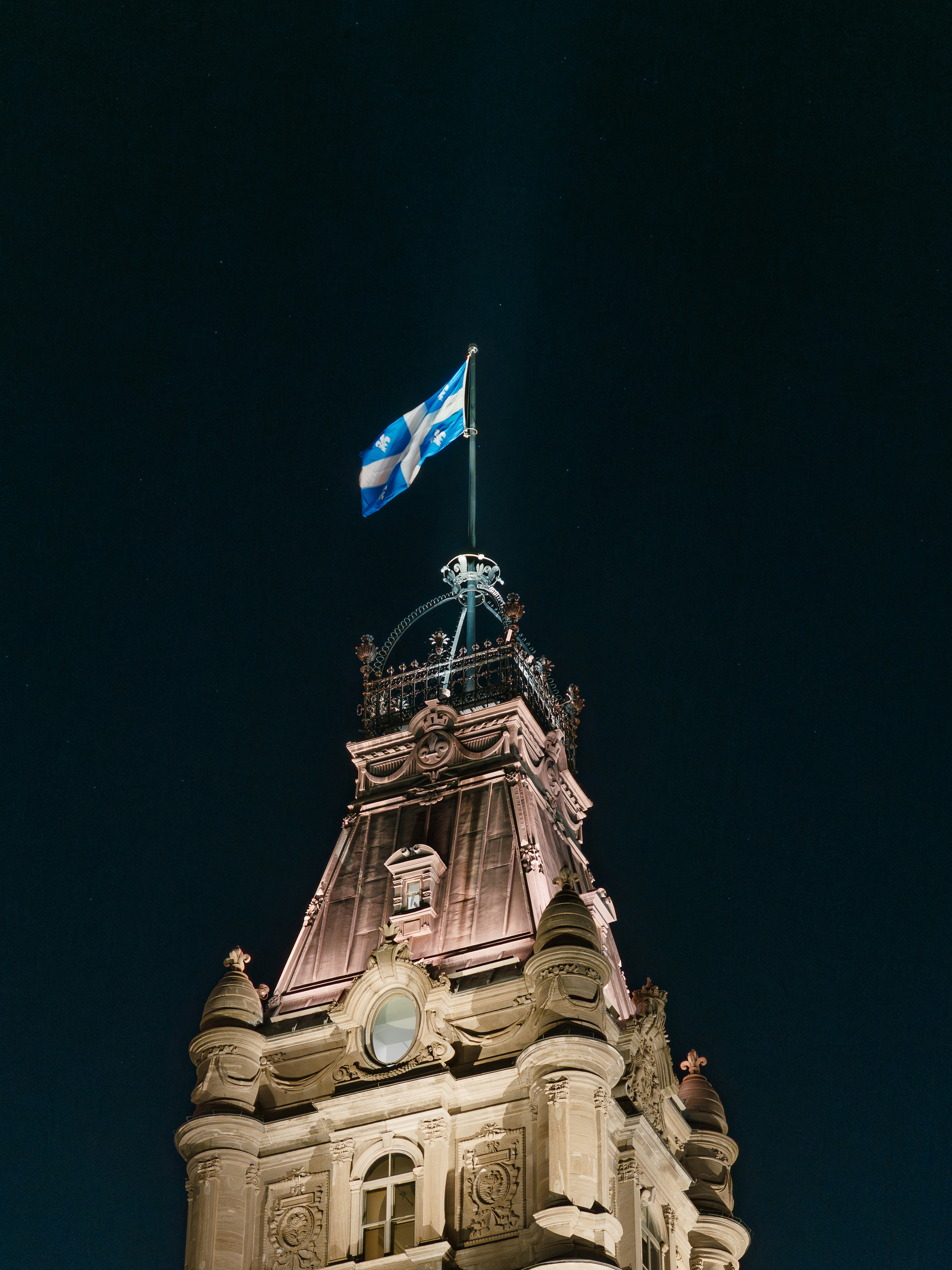 Flag atop a historic building at night