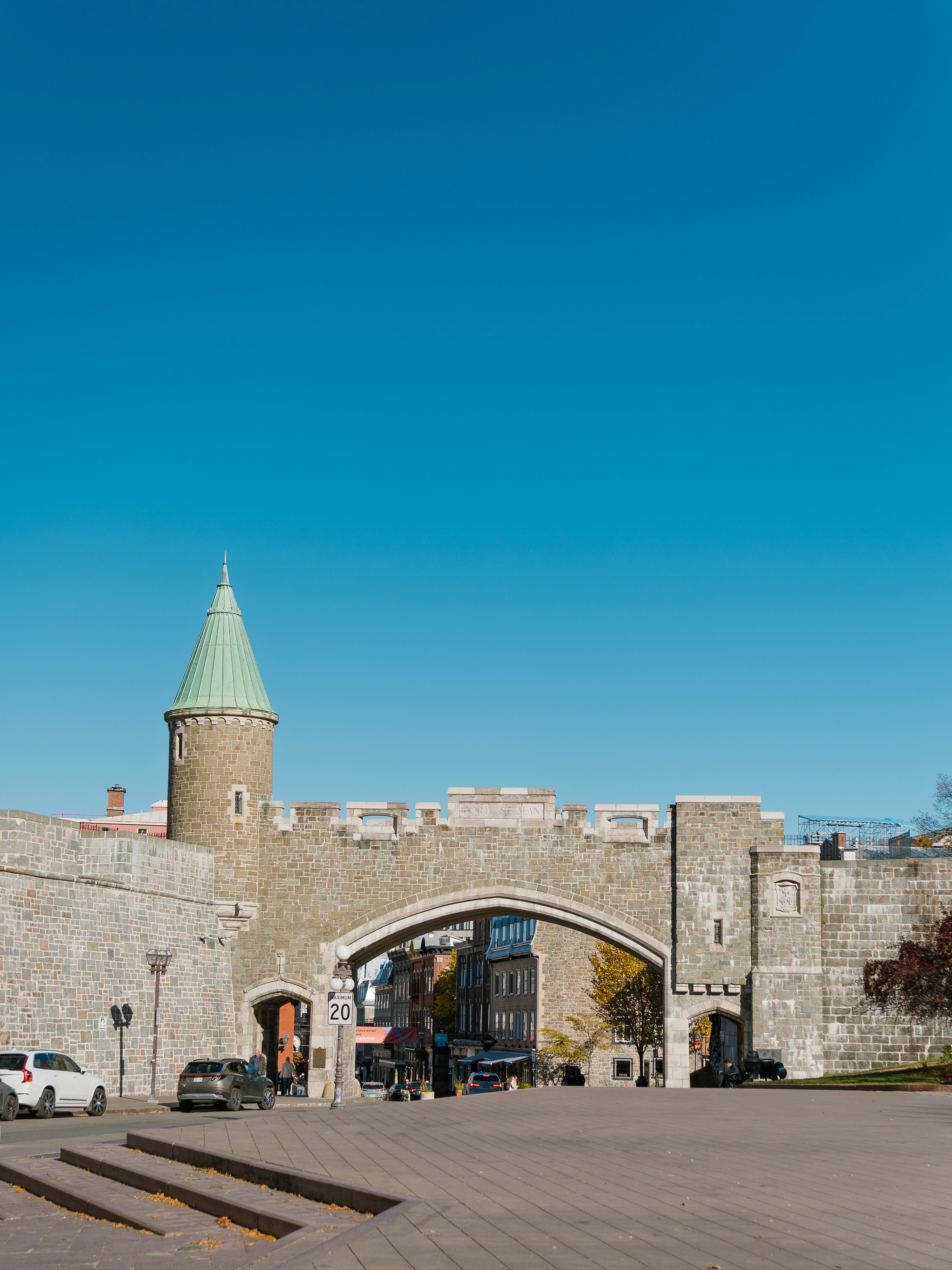 Historic stone gate with a green conical roof