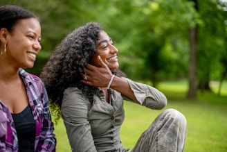 Two smiling women in a park