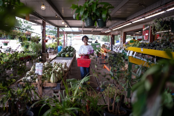 Woman shopping at a plant nursery with a basket