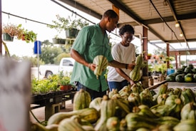 Couple shopping for gourds at an outdoor market.