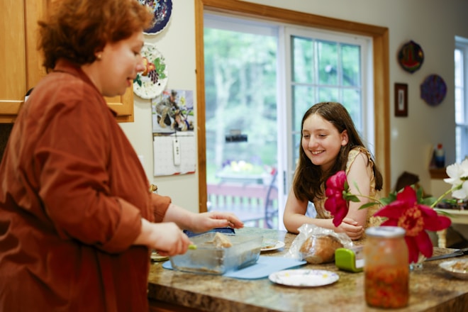 Woman preparing food with a girl watching