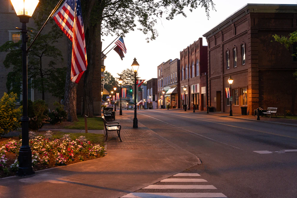 Small-town main street at dusk with American flags