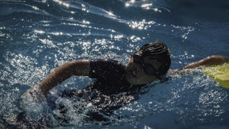 A young boy swims laps in a pool.