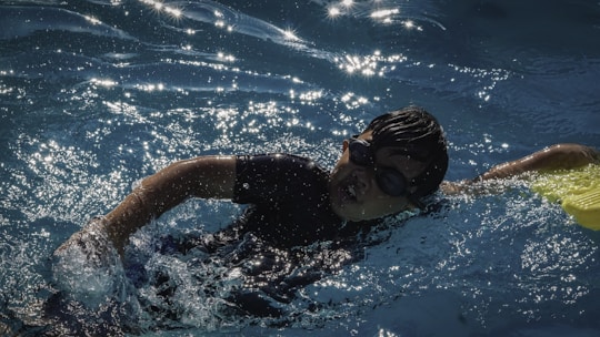 A young boy swims laps in a pool.