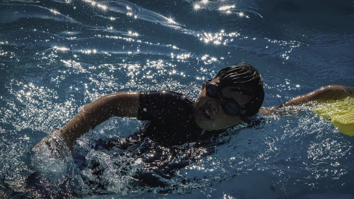 Swimmer training with a female swim coach in a home pool