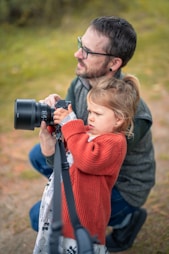 Man and child holding a camera together