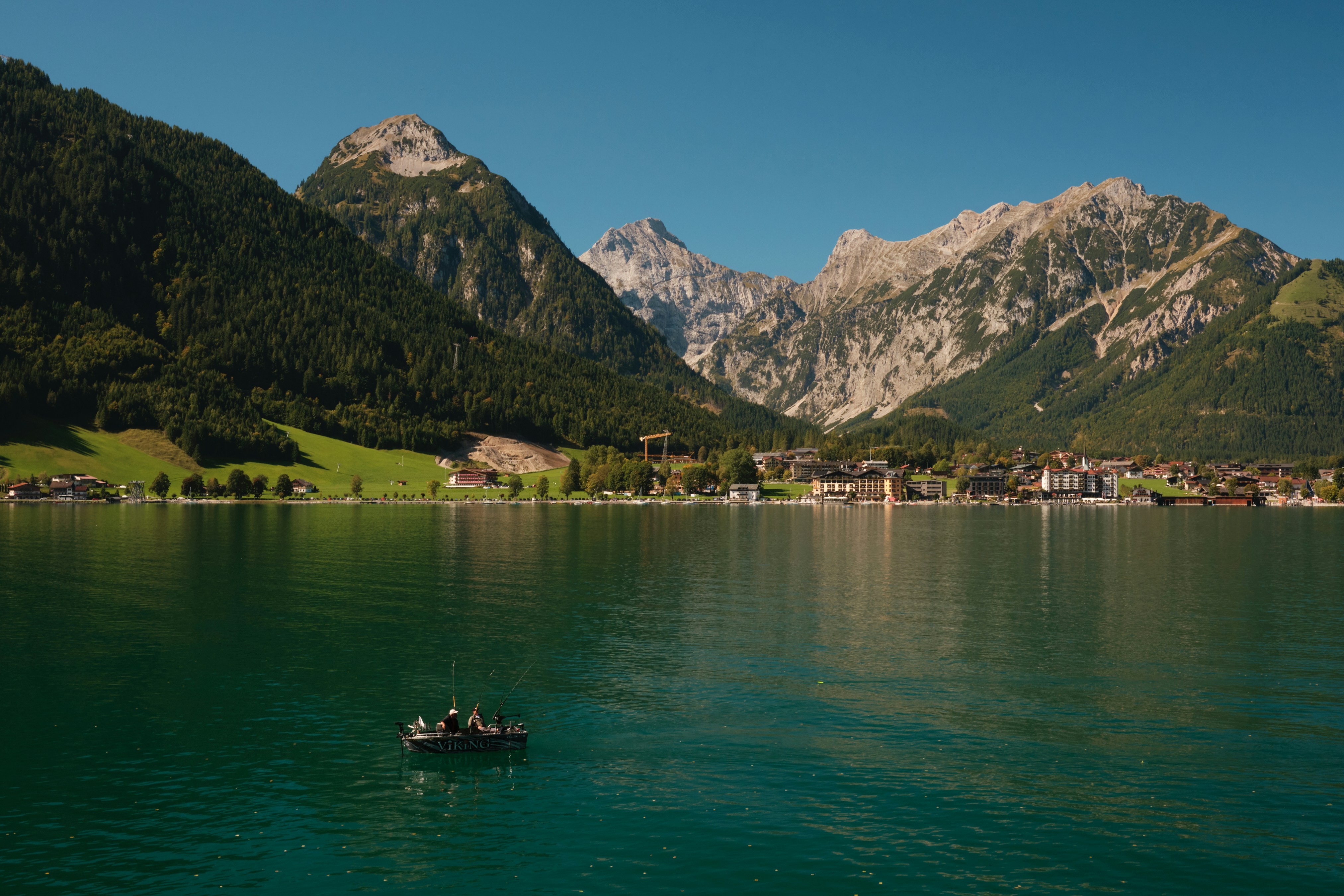 Barca su un lago con montagne e sfondo del villaggio