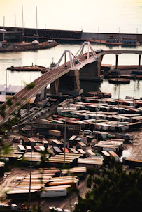 Modern bridge over a busy industrial port with containers.