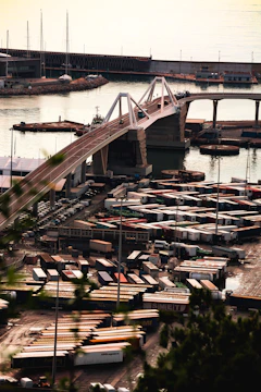 Modern bridge over a busy industrial port with containers.