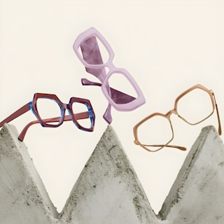 Three stylish glasses frames on concrete shapes