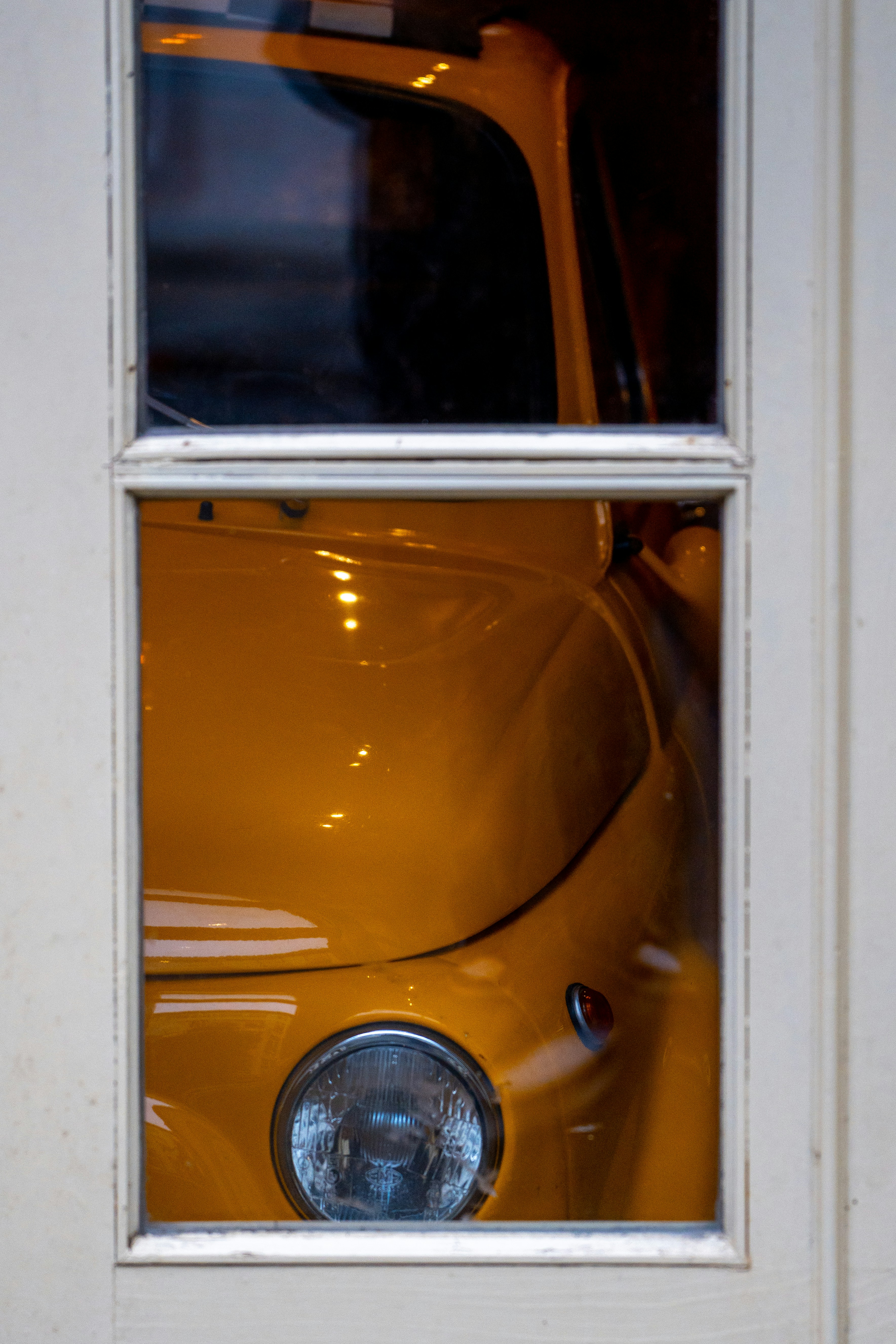 Yellow vintage car seen through a window