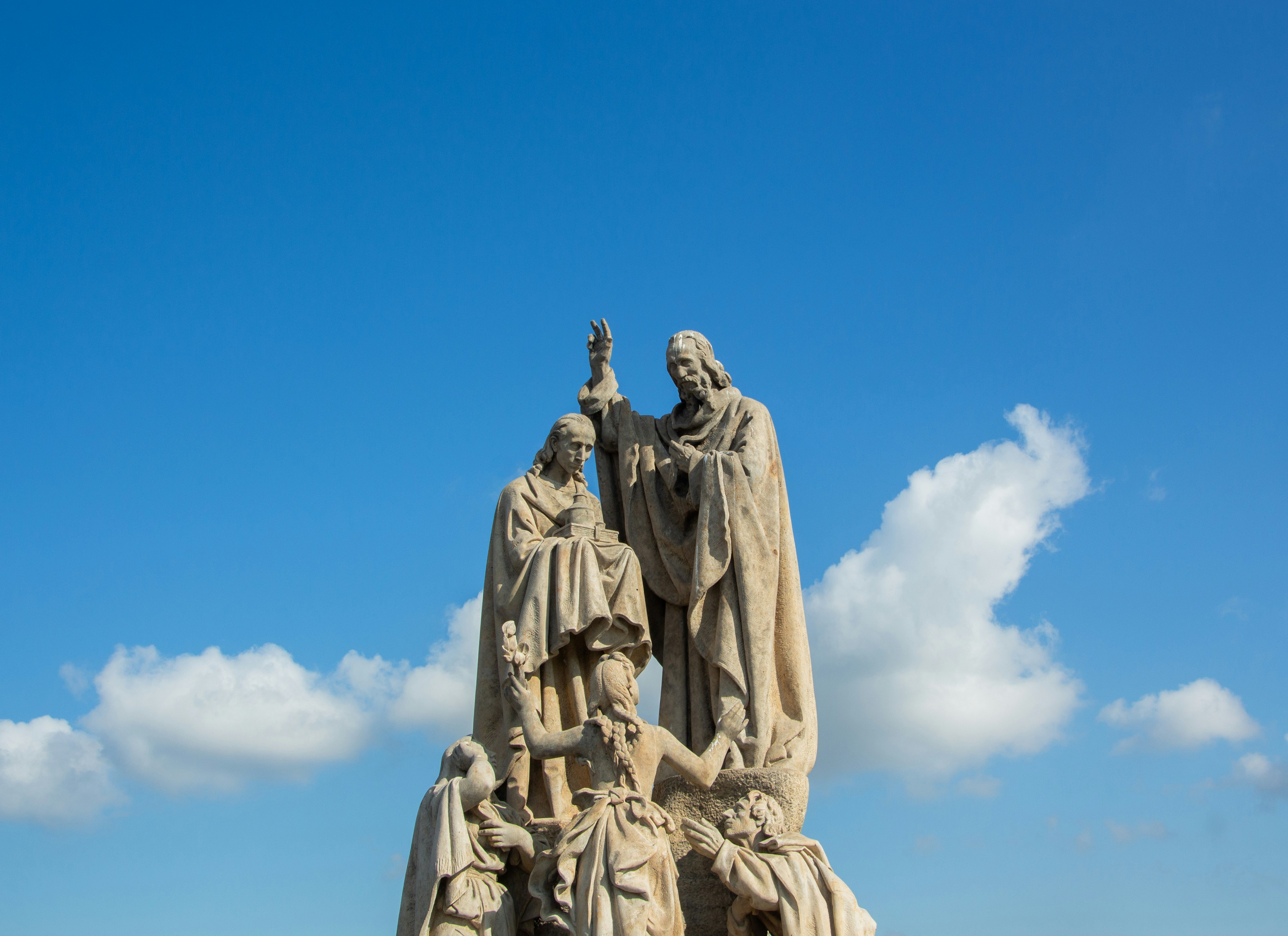 Stone statues against a bright blue sky