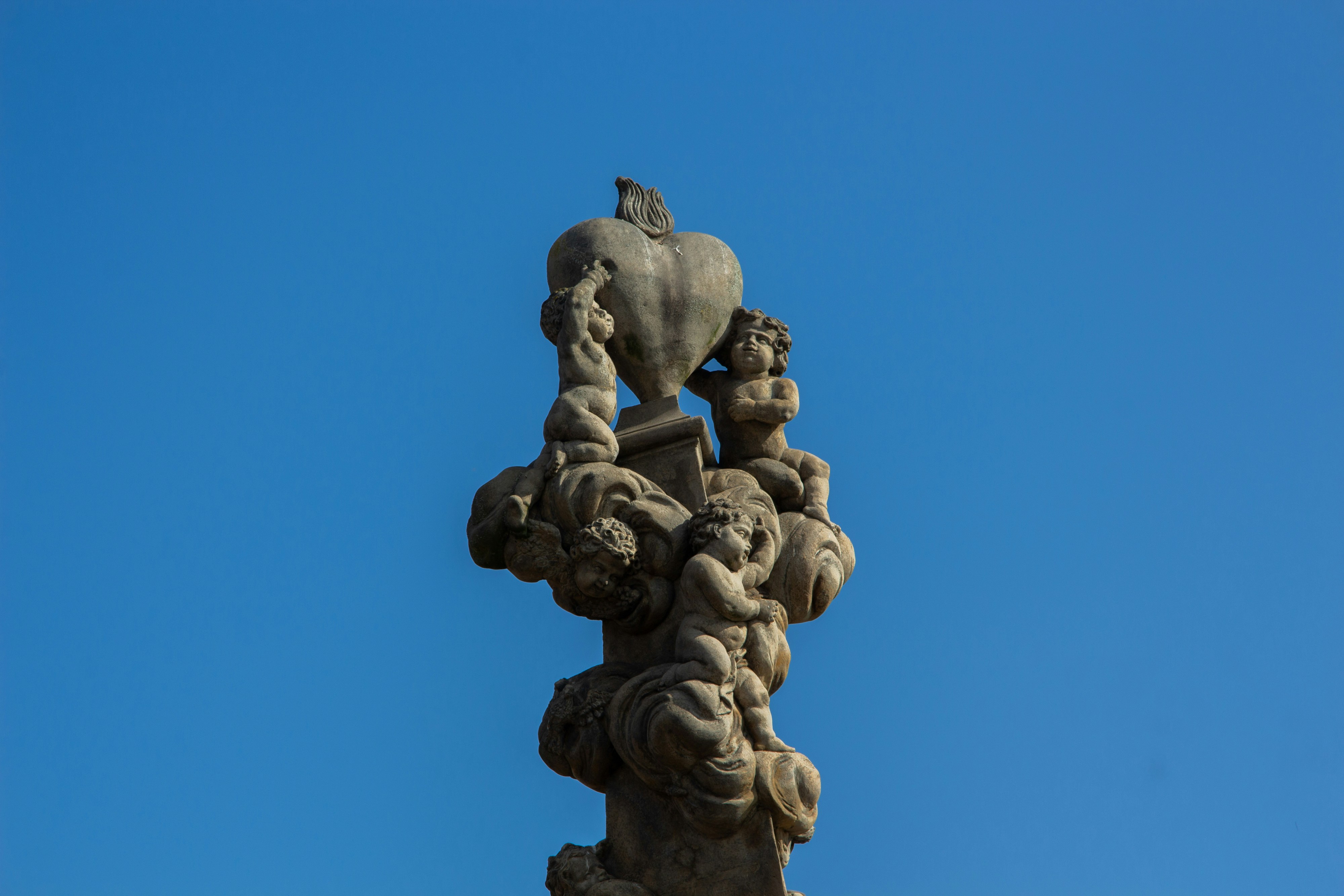 Stone sculpture of a heart with a bird on top.