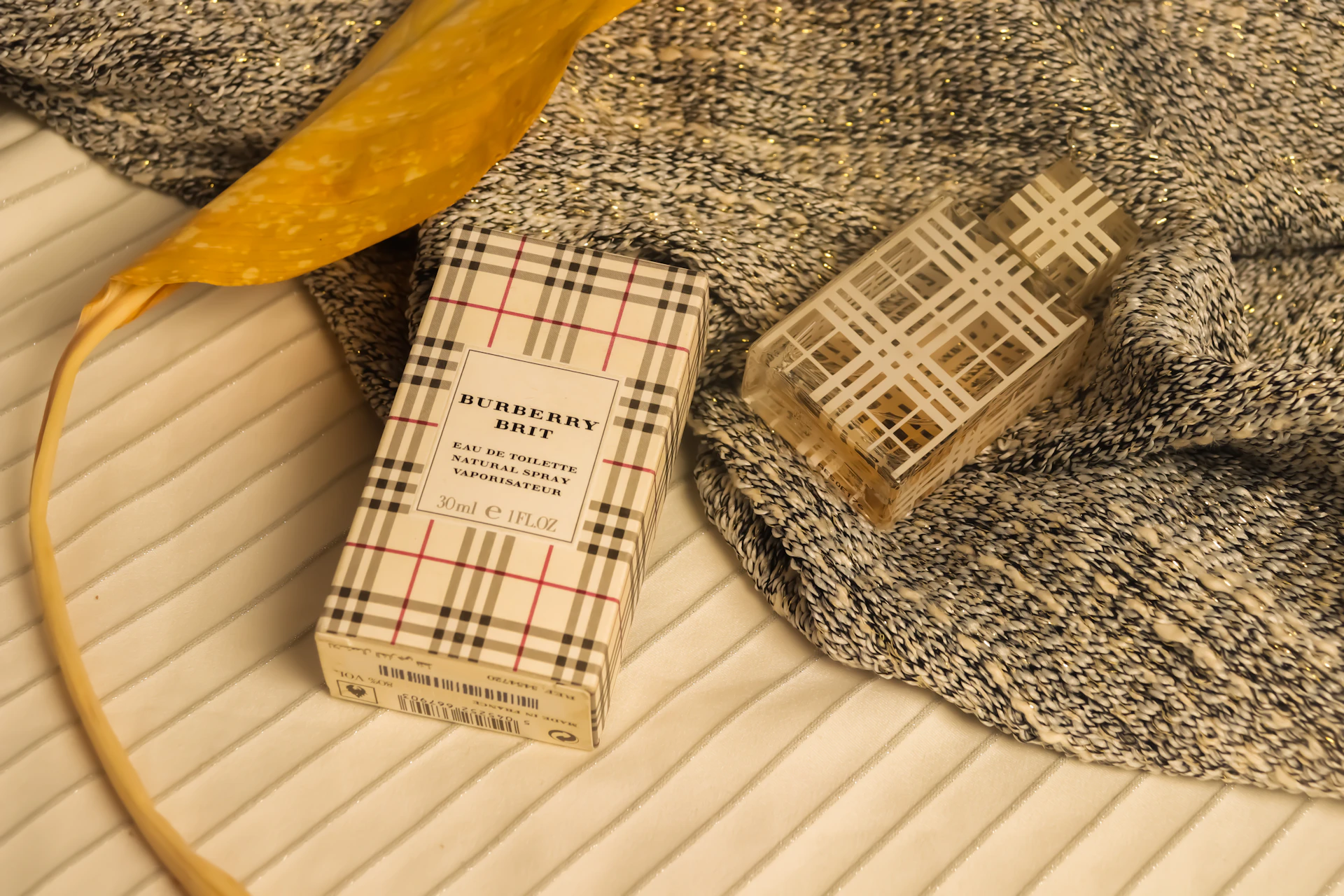 Burberry brit perfume bottle and box on textured fabric