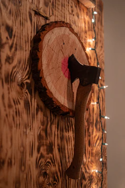 Axe stuck in a wooden target board.