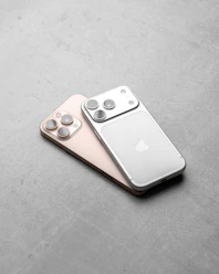 Two iphones resting on a textured surface