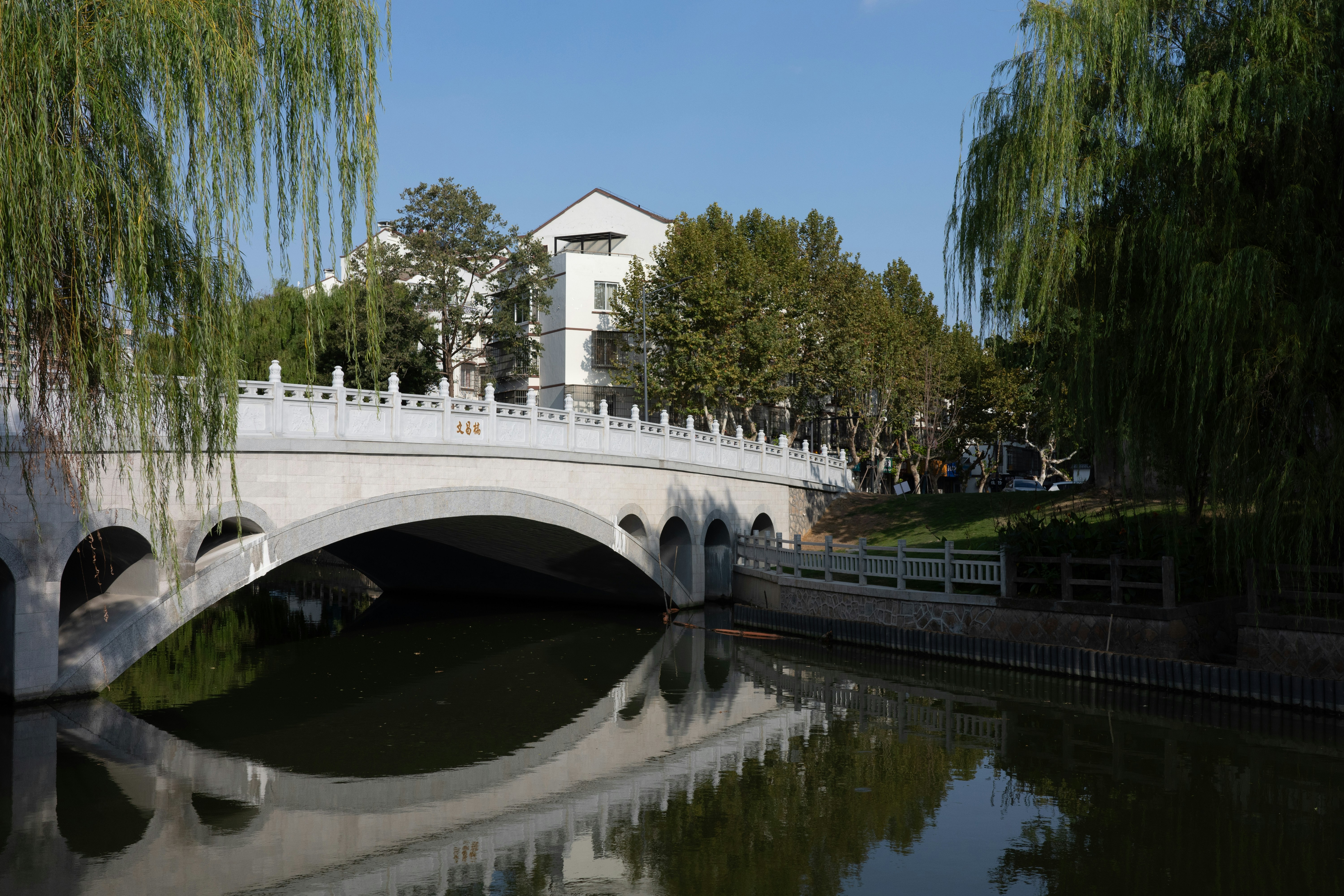 White arched bridge over a calm river