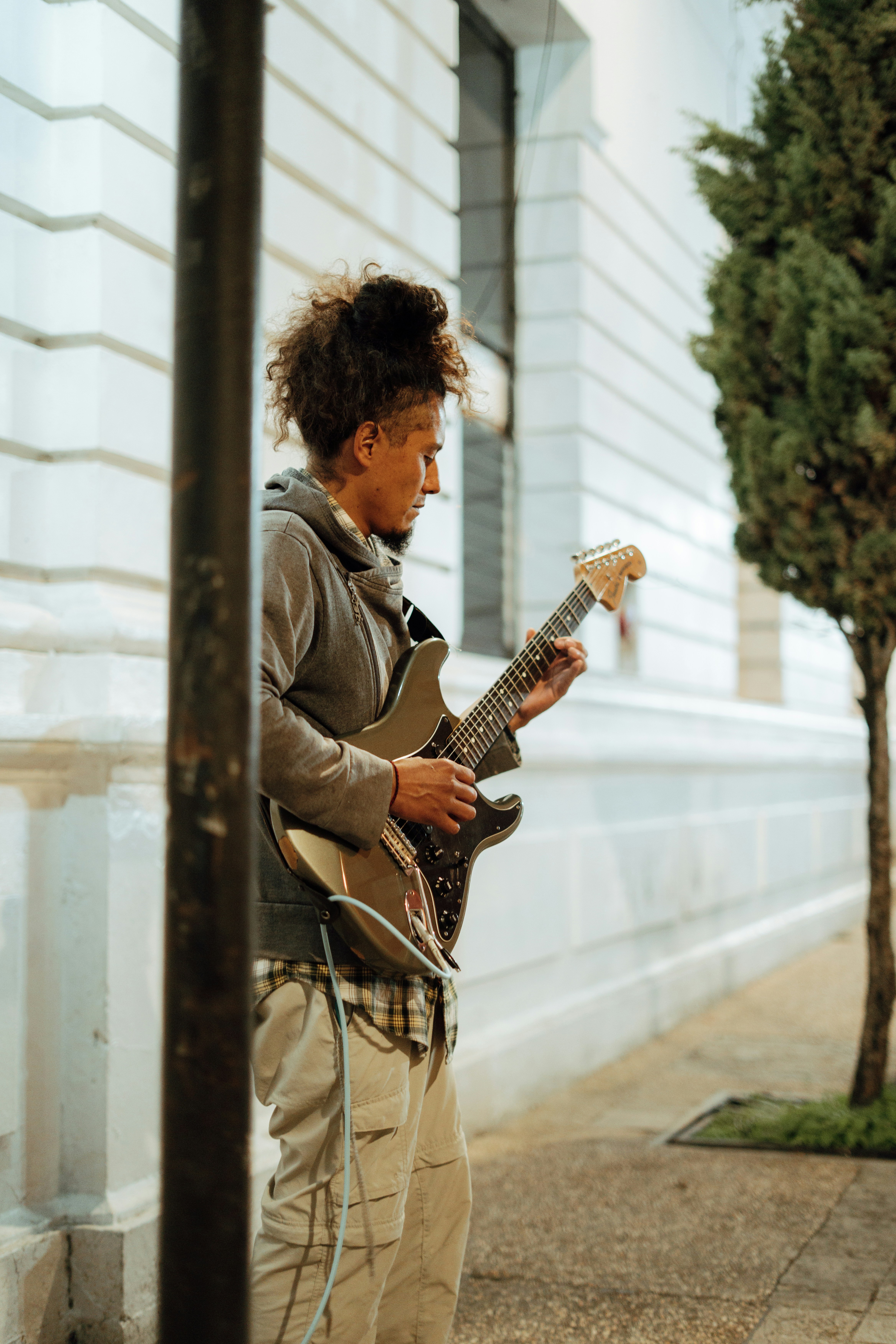 Man playing electric guitar on sidewalk
