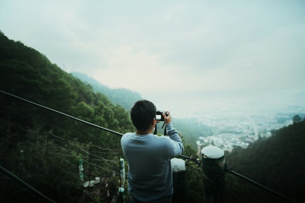 Man photographing a city from a mountain viewpoint — San Cristóbal de las Casas, Mexico