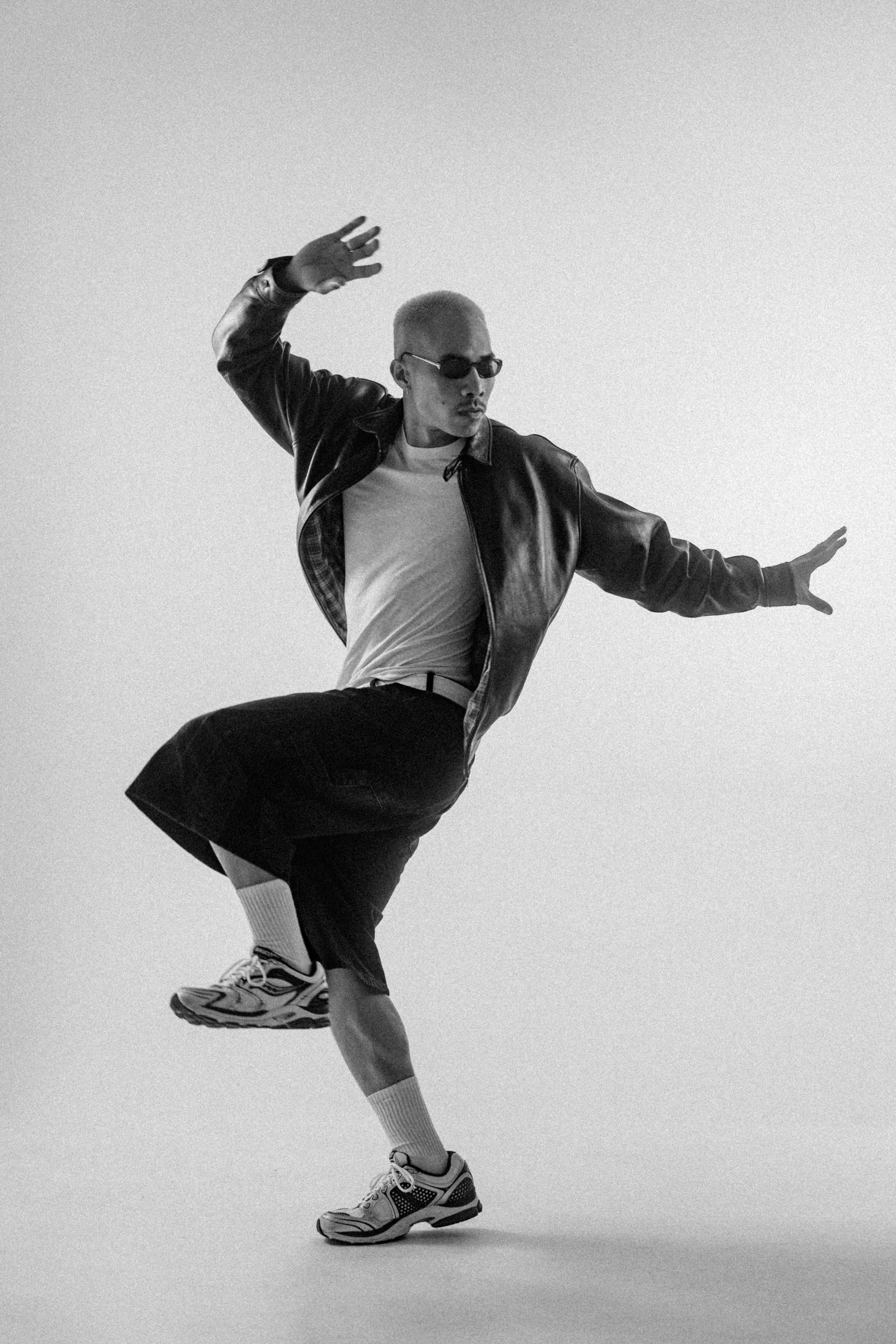Bald man in sunglasses dancing in studio
