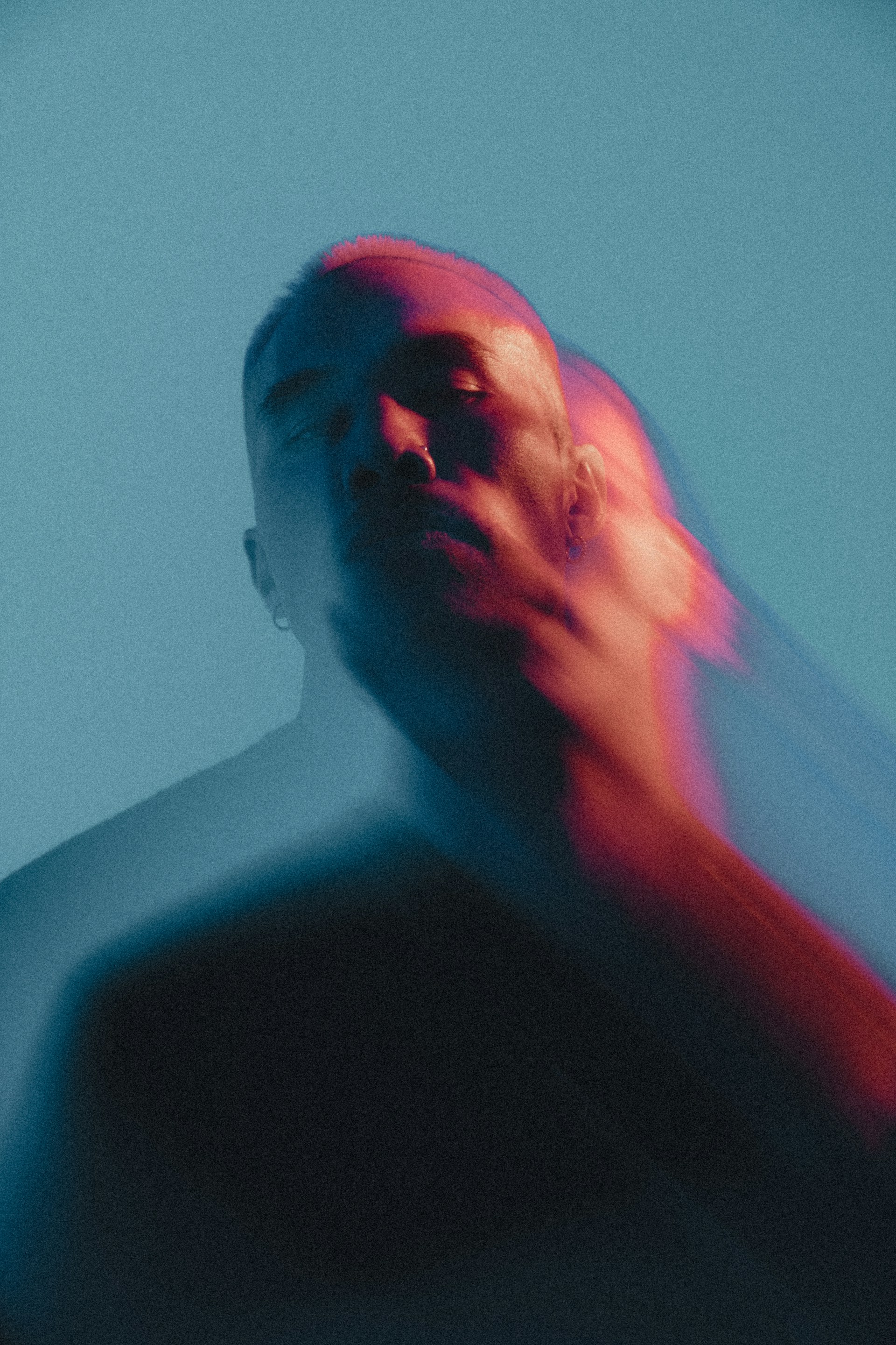 Man with blurred face in red and blue light