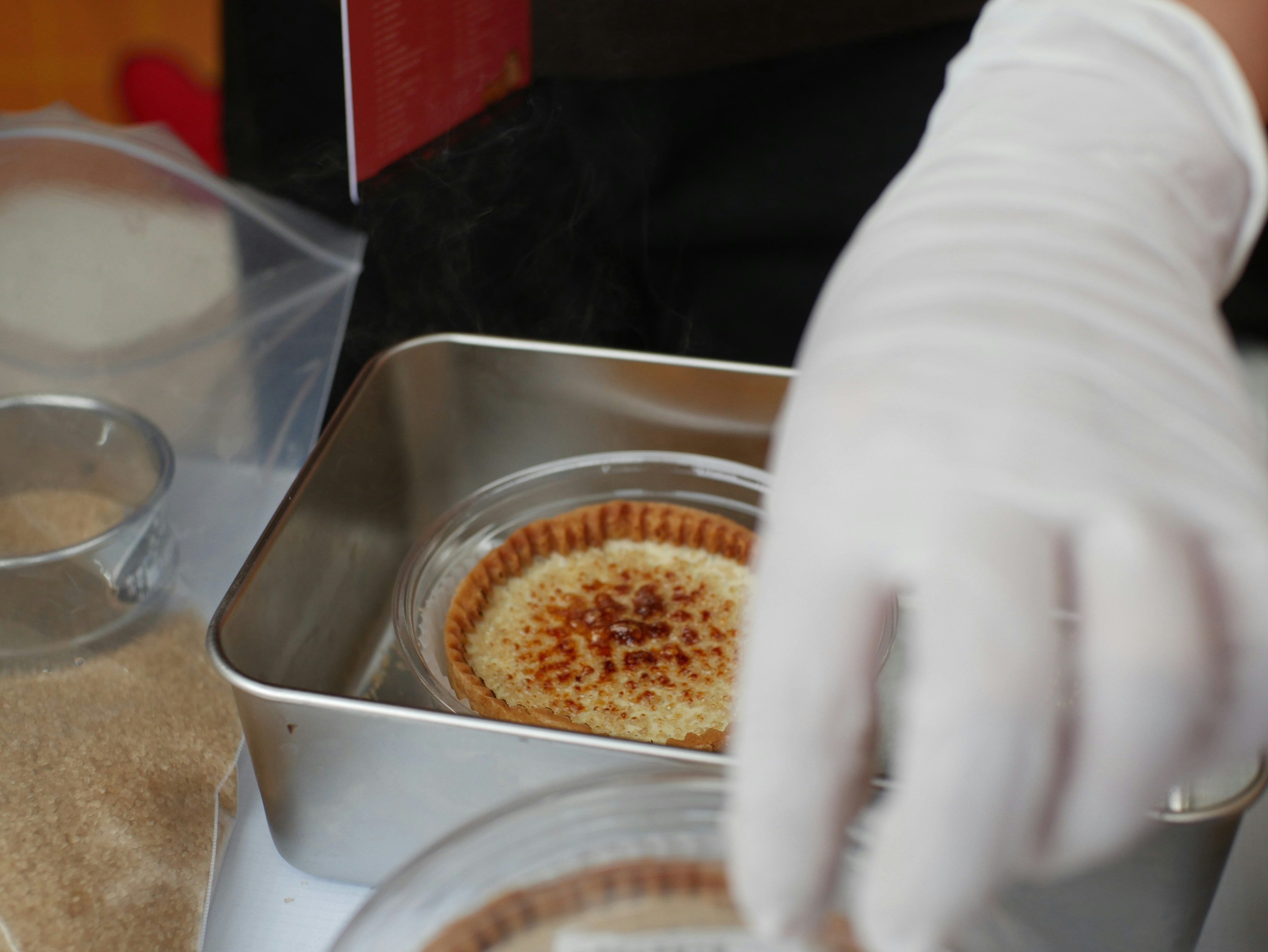 Chef in gloves preparing creme brulee desserts