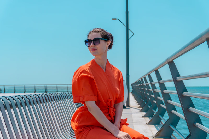mujer en vestido naranja sobre el muelle