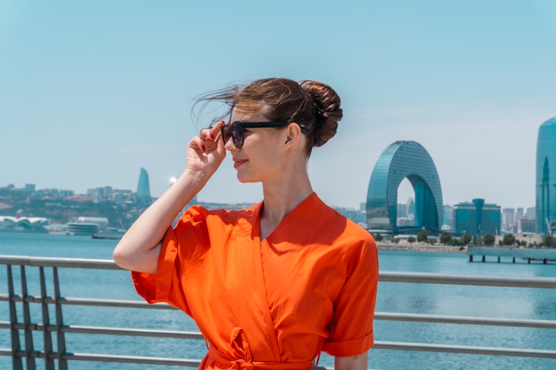 Confident woman in bold orange dress and sunglasses