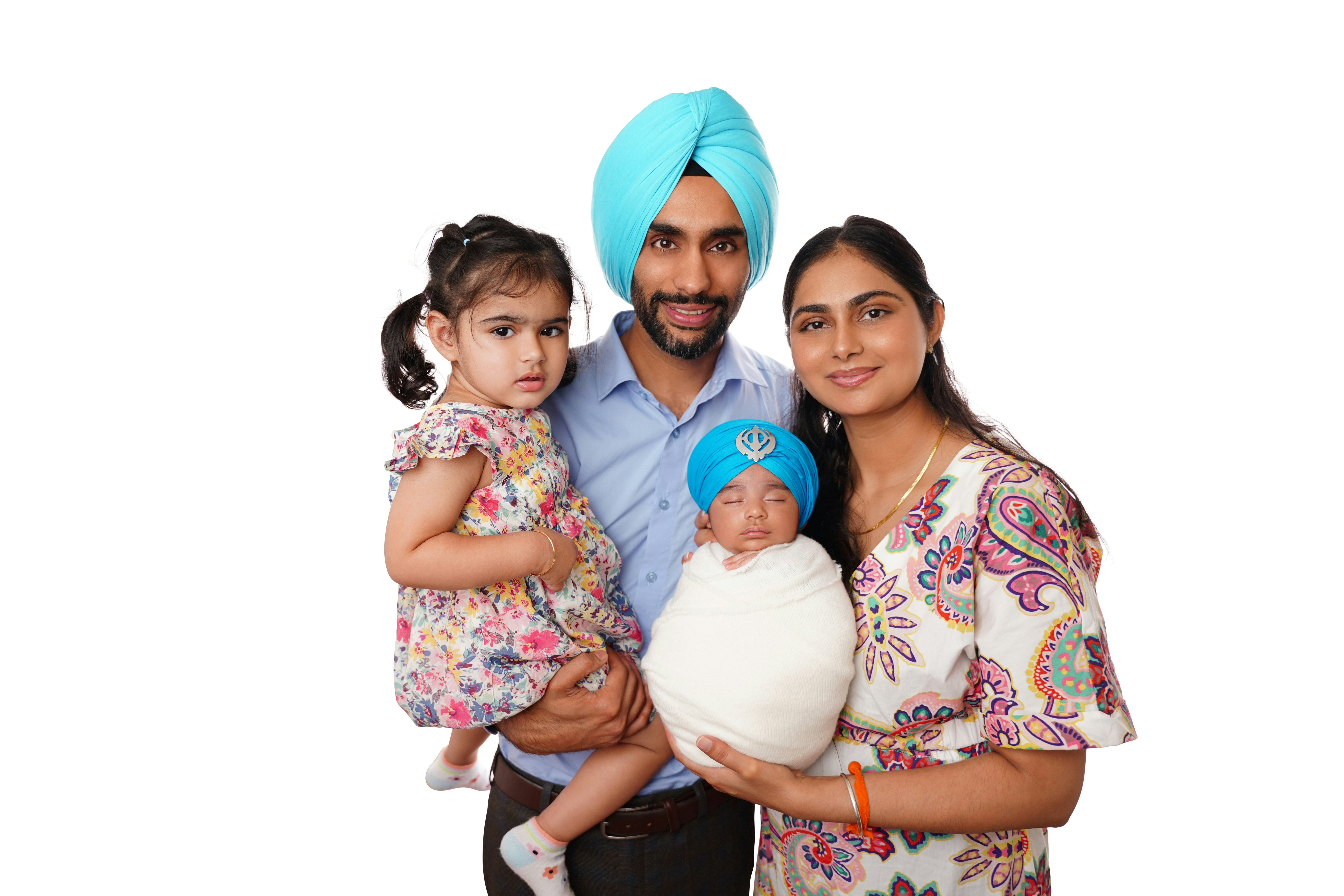 Family posing with newborn baby and toddler daughter.