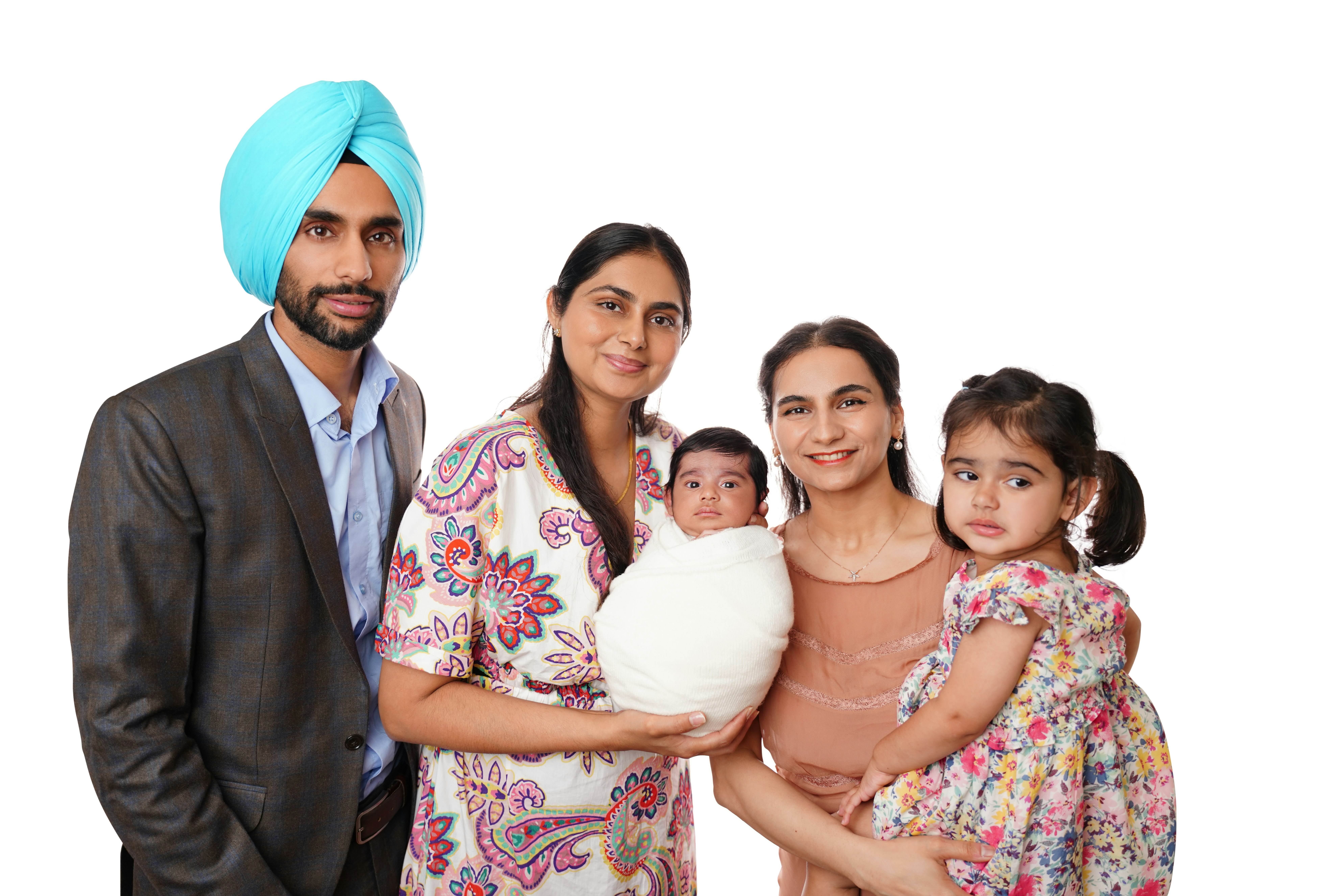 A sikh man, two women, and two children