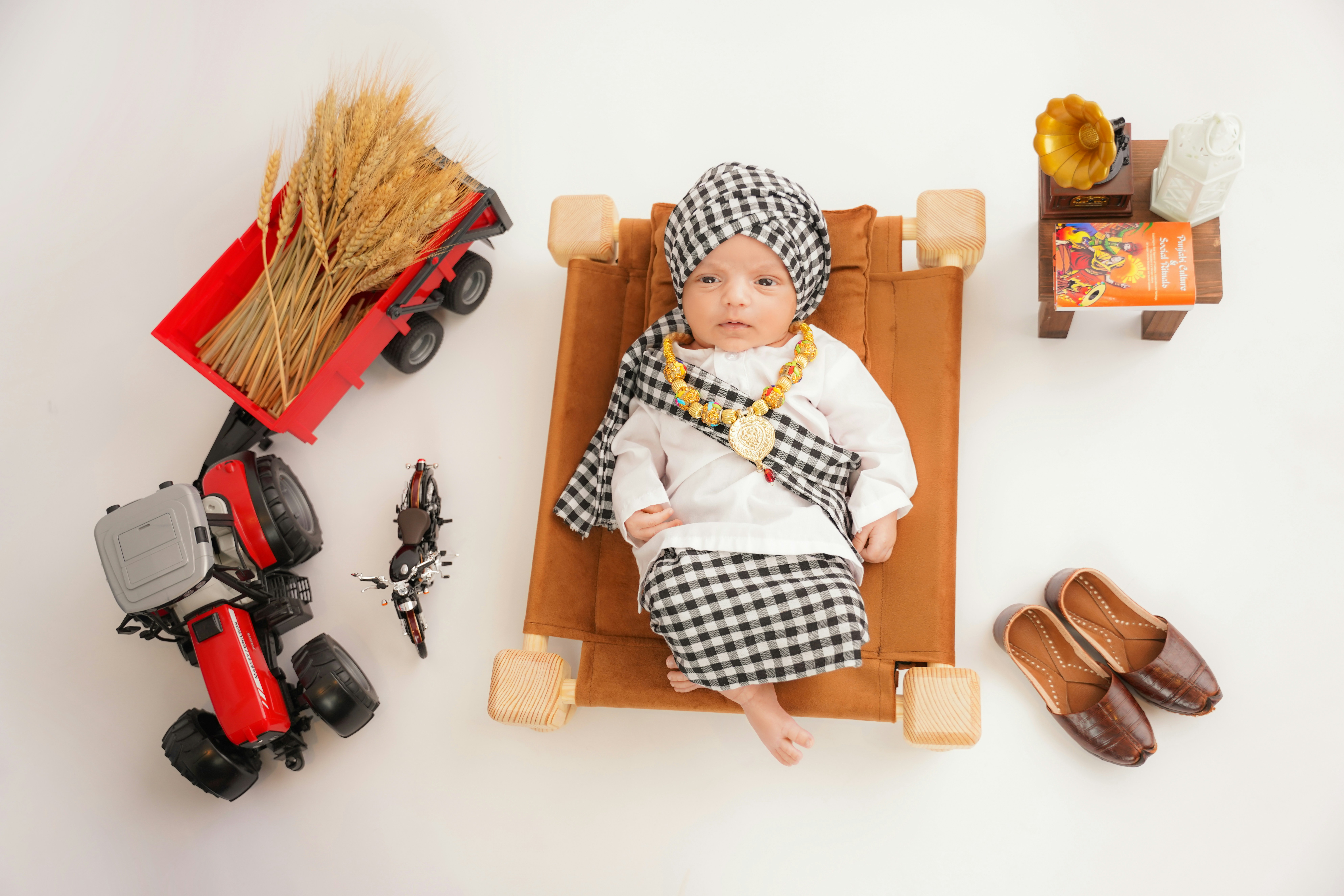 Baby dressed as a farmer with tractor and wheat