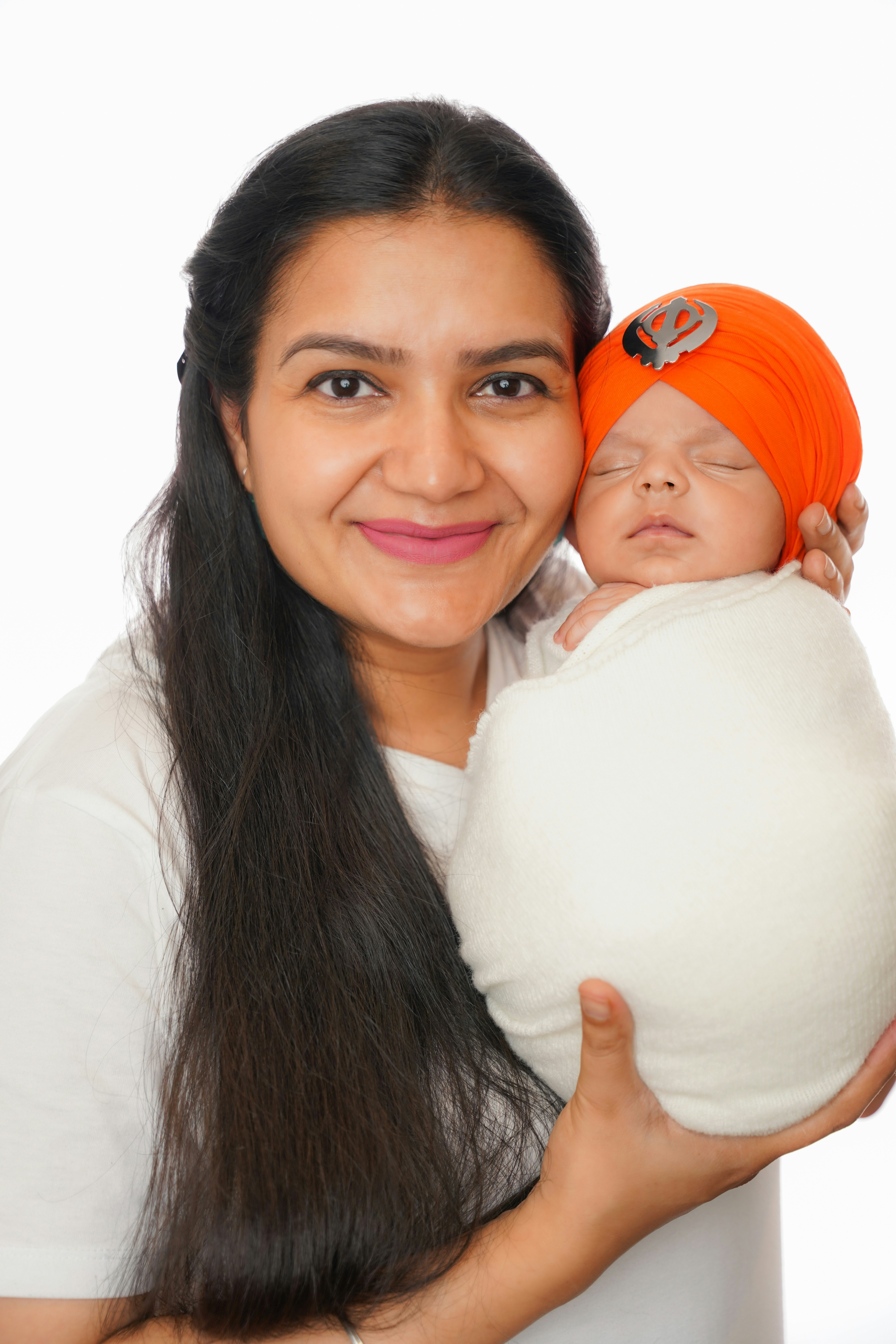Mother holding her newborn baby wearing a turban