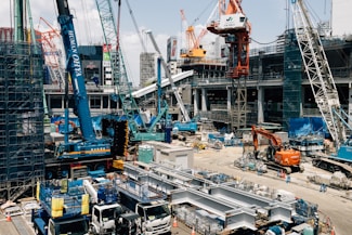 Busy construction site with many cranes and trucks.
