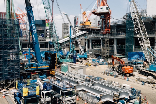 Busy construction site with many cranes and trucks.