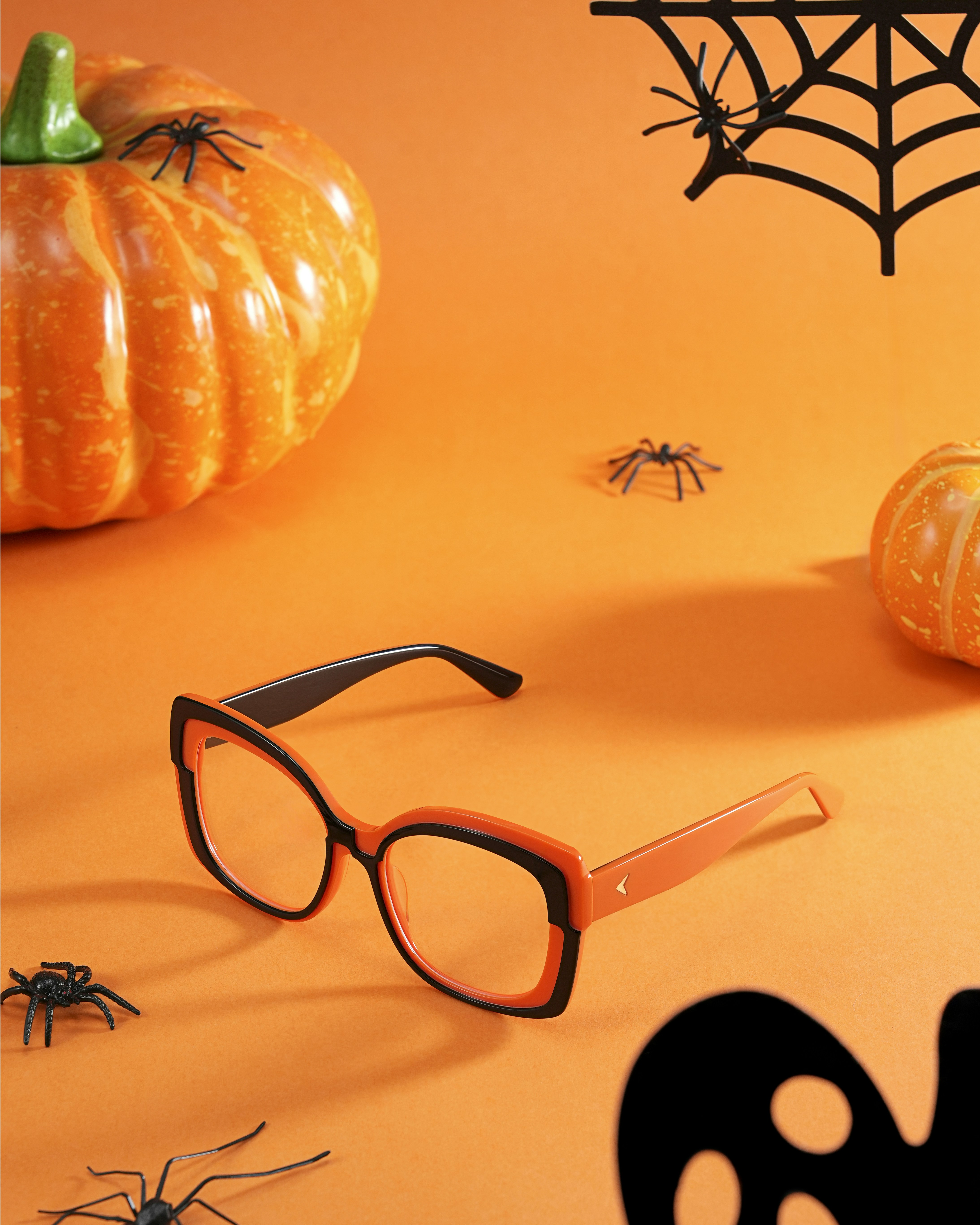 Halloween decorations with pumpkins, spiders, and glasses.