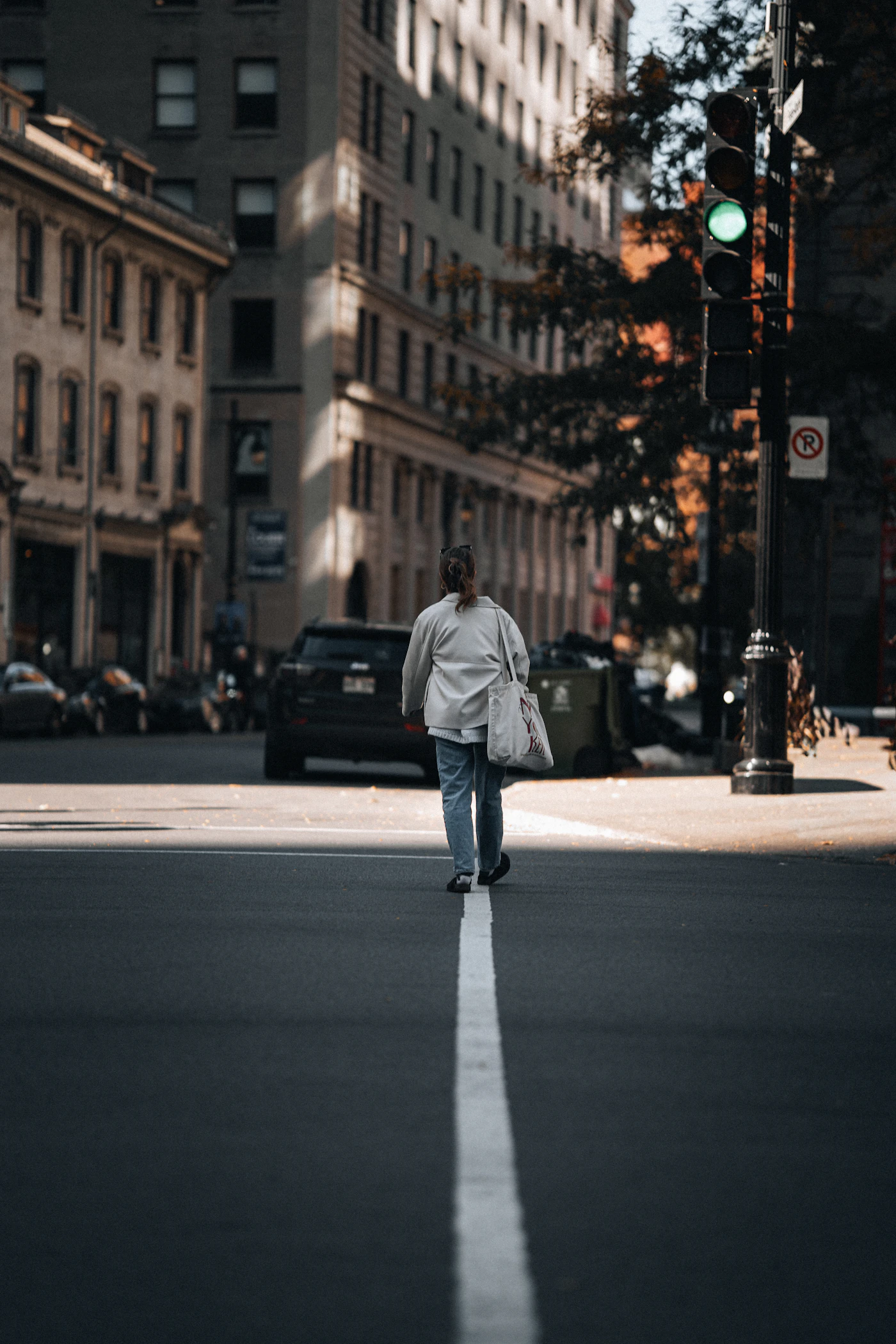 Woman crossing a sunny city street alone, representing rebuilding everyday life after a breakup