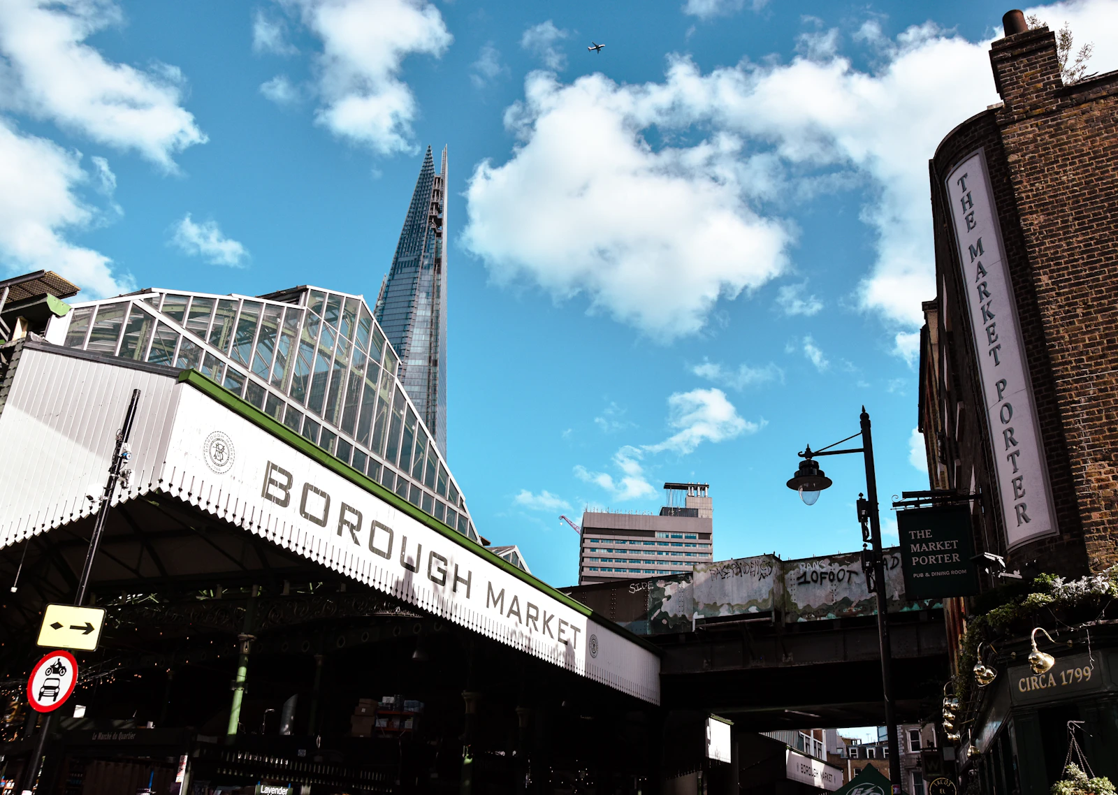 Photograph of The entrance to Borough Market with a modern glass tower rising behind it.