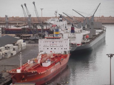 Cargo ships docked at a busy industrial port.