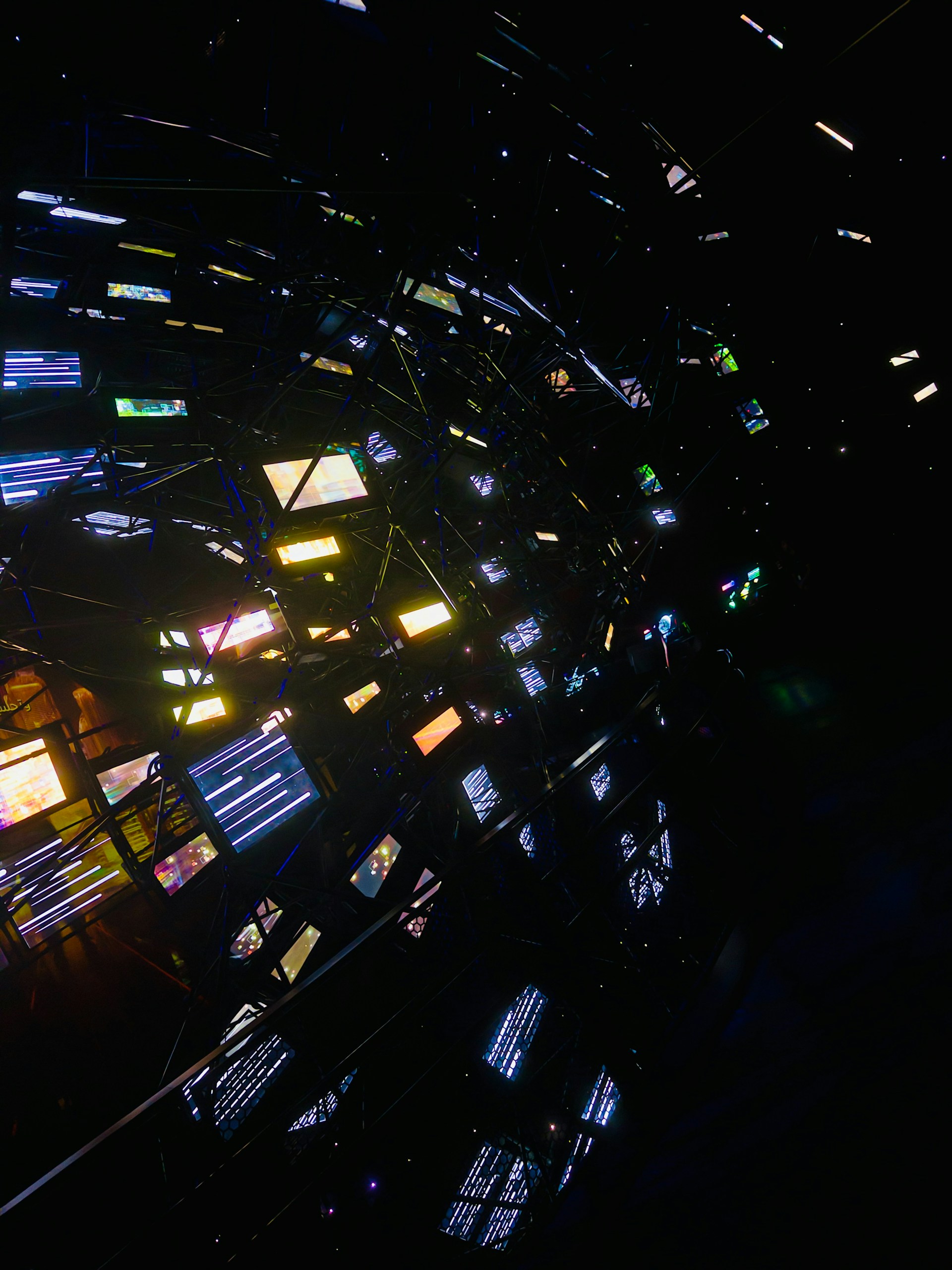 Abstract network of glowing screens in darkness