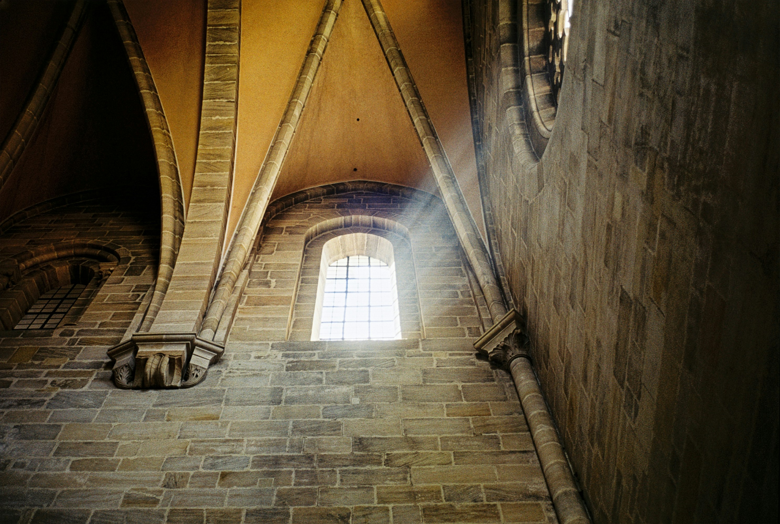 Sonnenlicht strömt durch ein gotisches Domfenster.