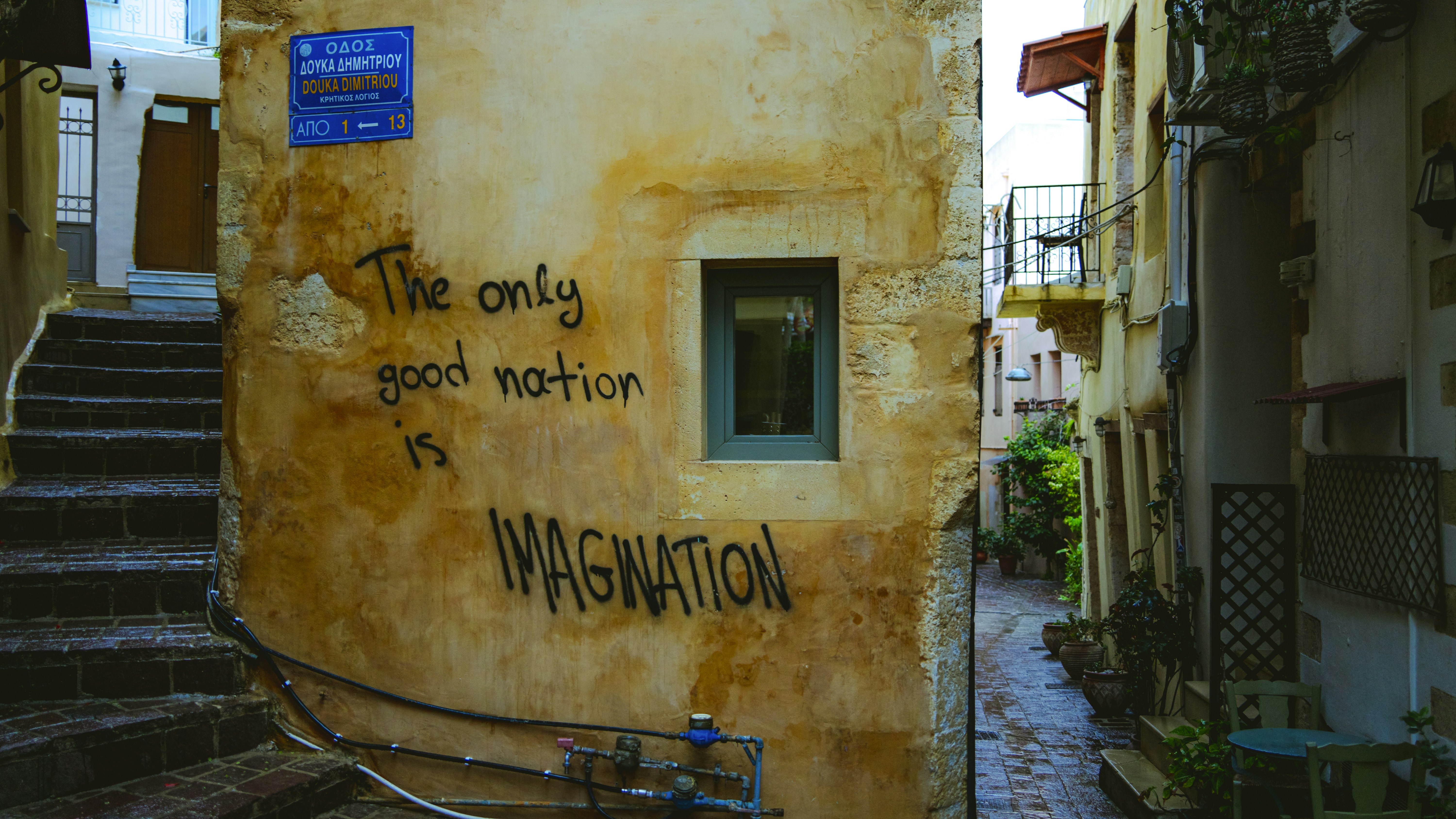 Graffiti on a weathered wall in a narrow alley.