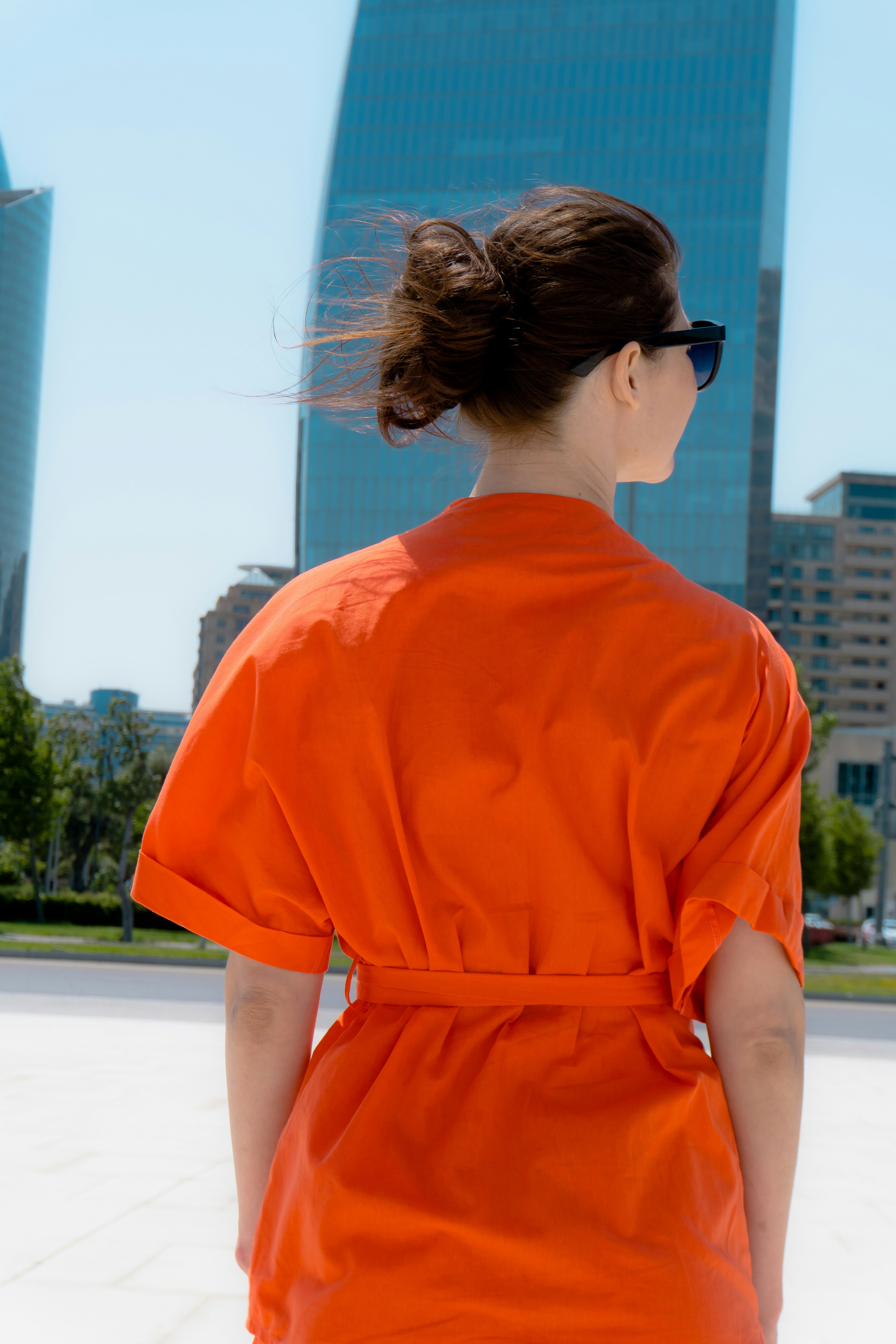 Woman in orange dress with city skyscrapers behind