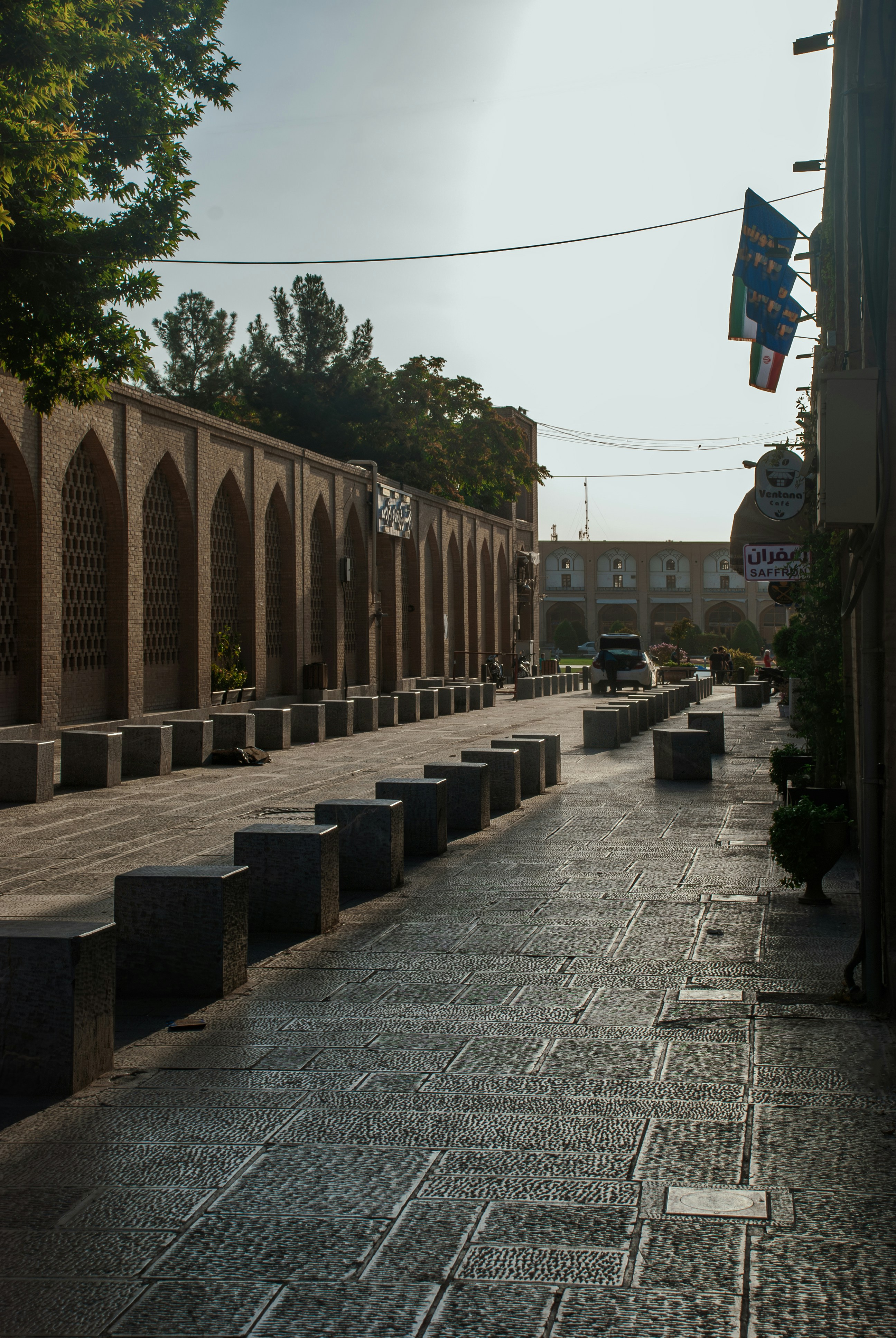 Stone walkway with arched building and flags