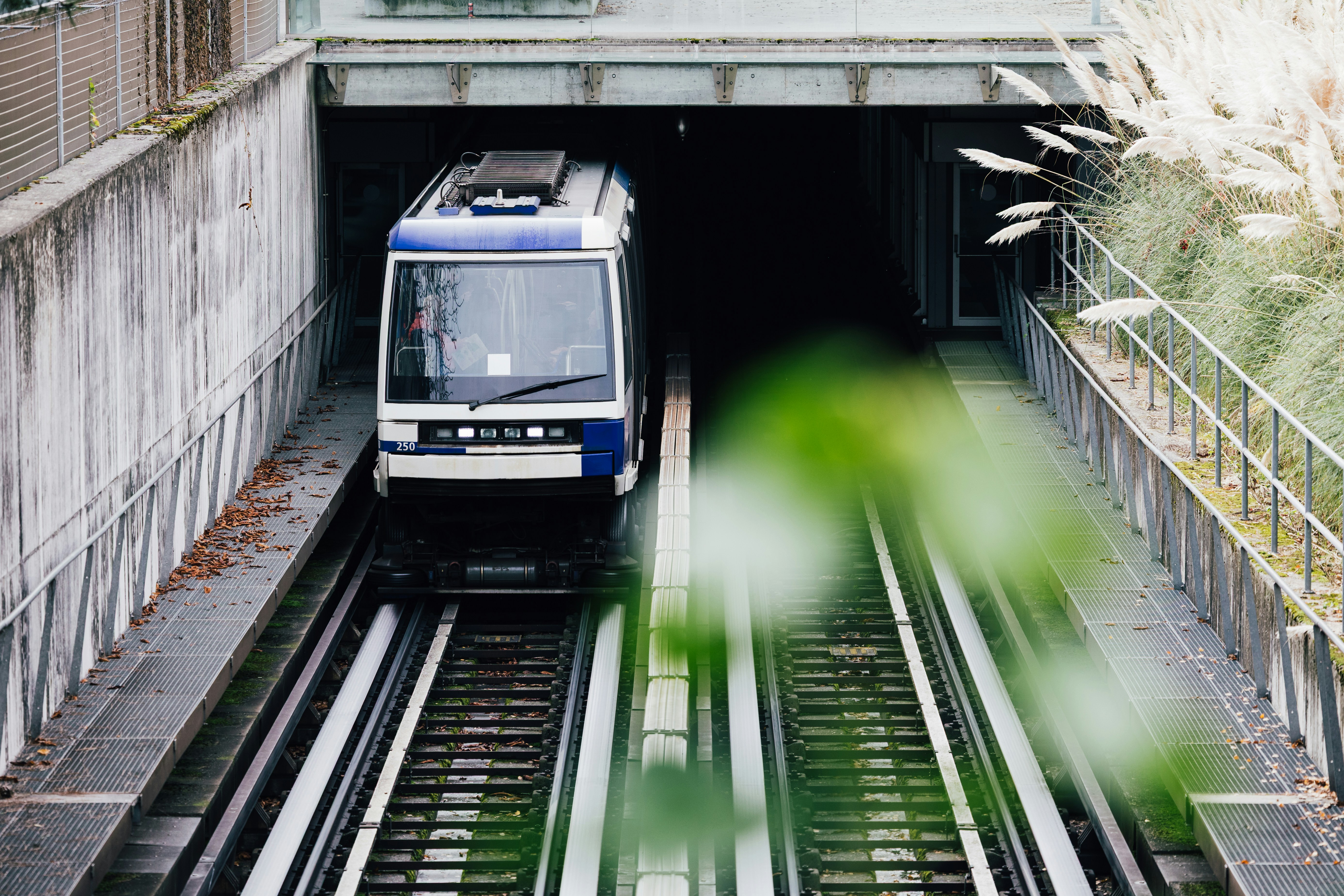 A train emerges from a tunnel on tracks.