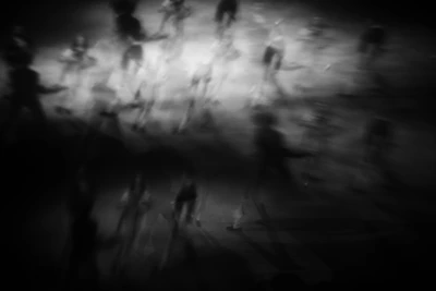 Blurred figures walking in darkness with bright light