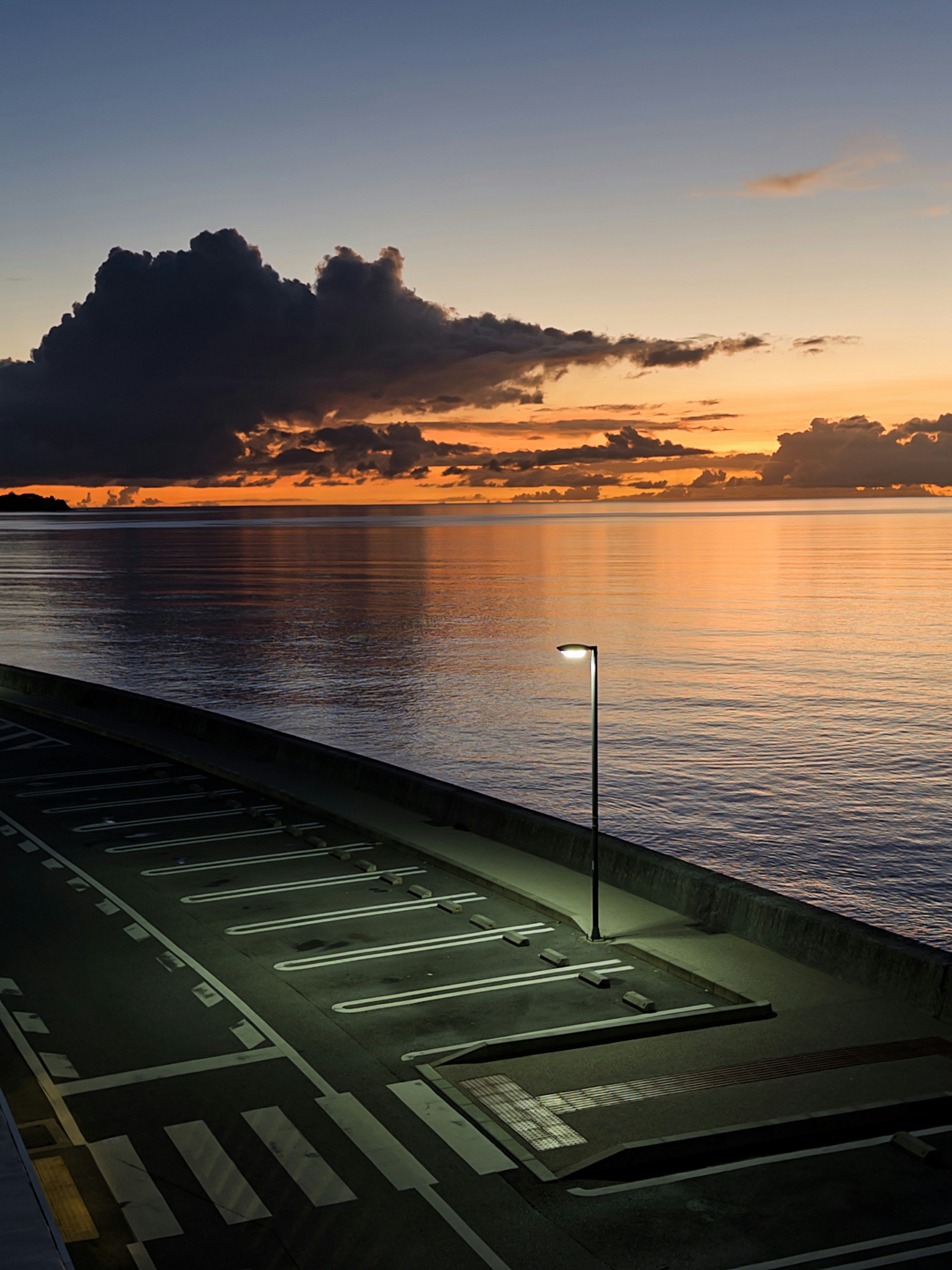 Empty parking lot by the ocean at sunset.