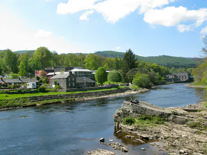 River flowing through a town with green hills