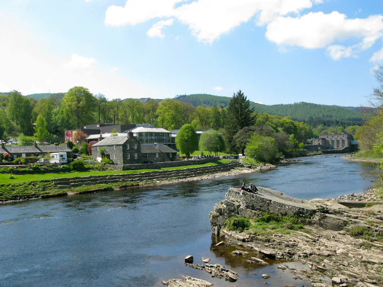 River flowing through a town with green hills